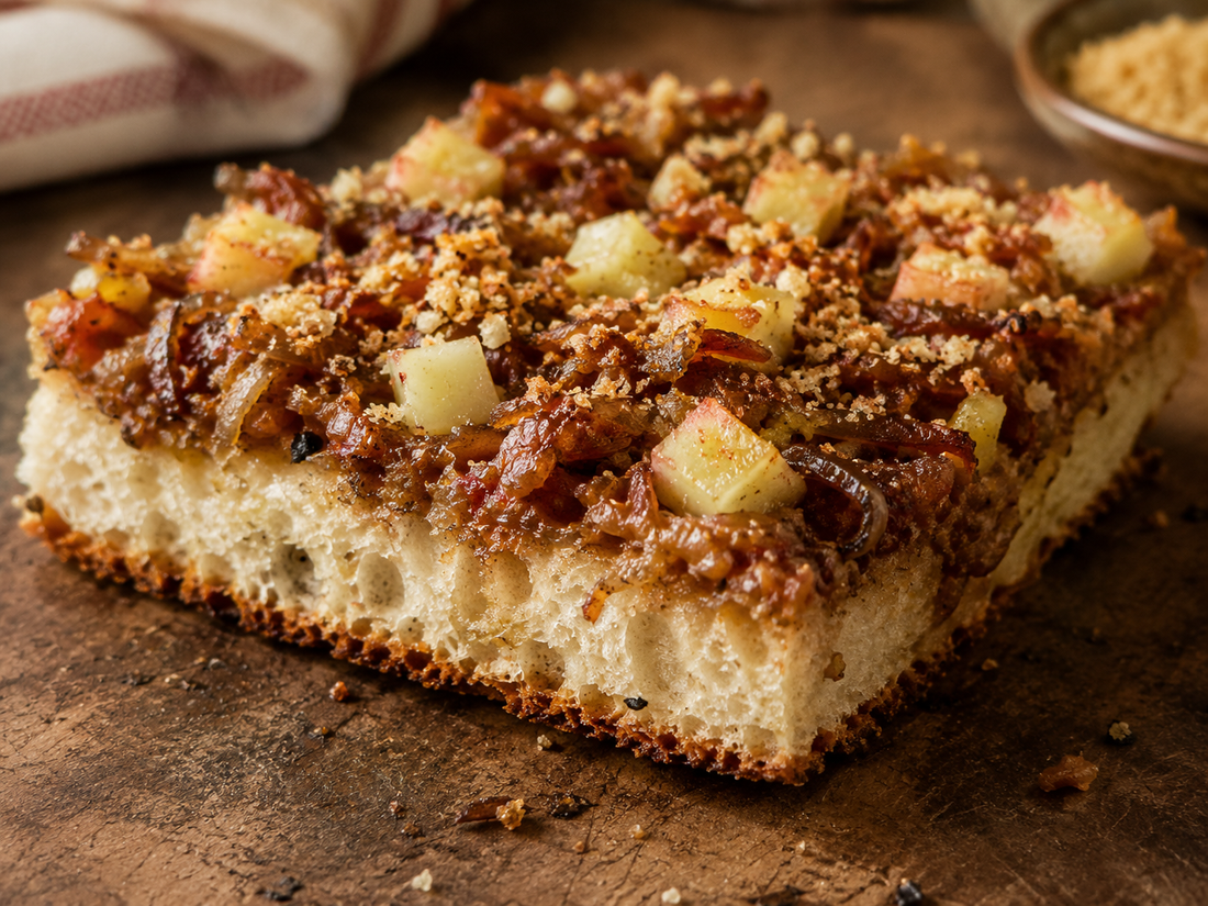 Thick spongy sfincione square with a golden crisp bottom, topped with onion sauce, anchovy, breadcrumbs and caciocavallo