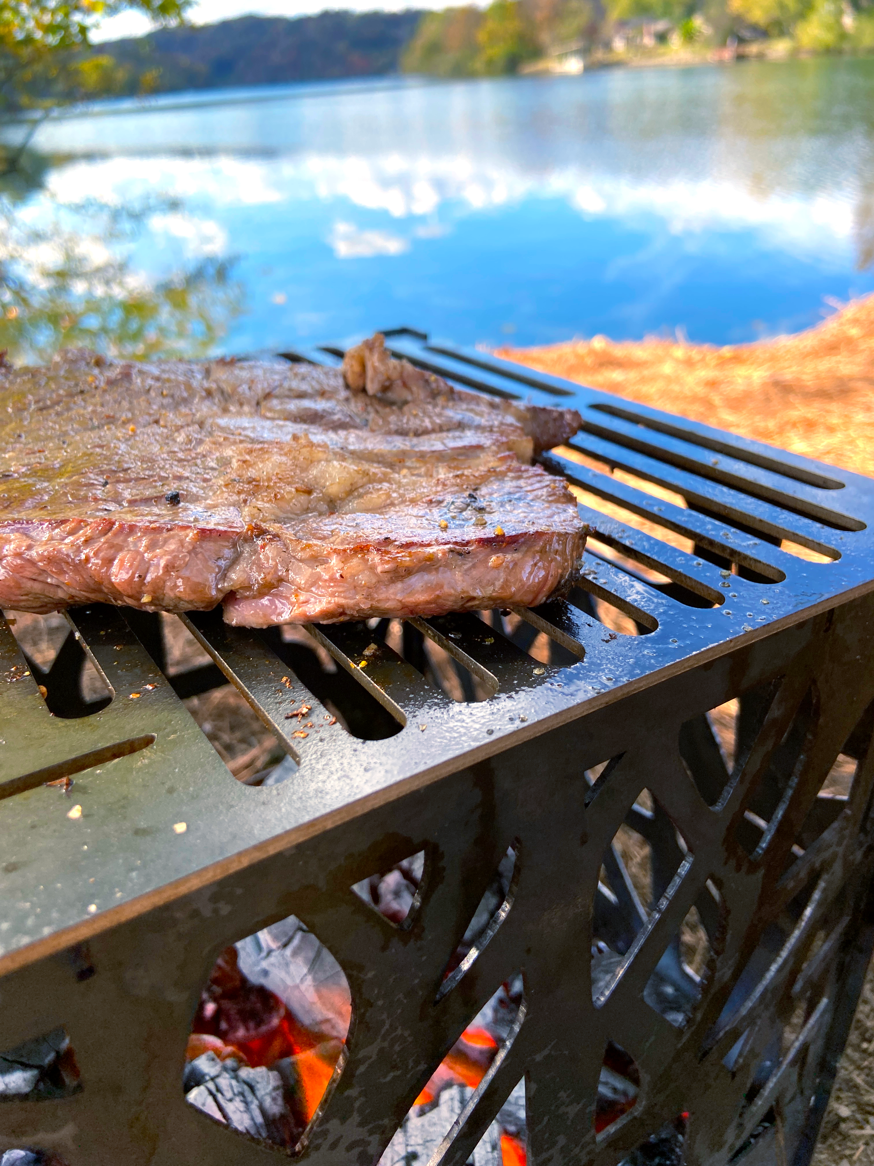 Sizzling steak on fire pit grill