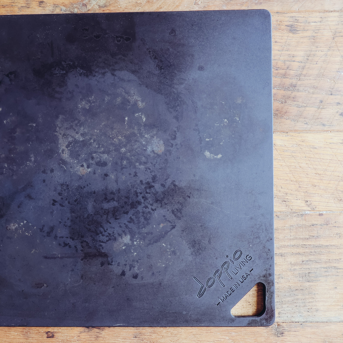 Seasoned carbon steel pizza steel showing natural patina and cooking surface used for baking pizza in oven